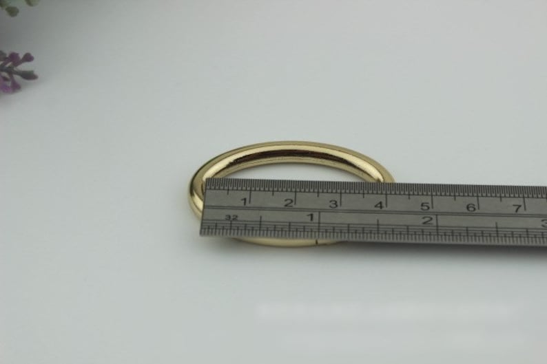 May include: A gold metal ring with a diameter of approximately 3 inches, measured with a ruler.
