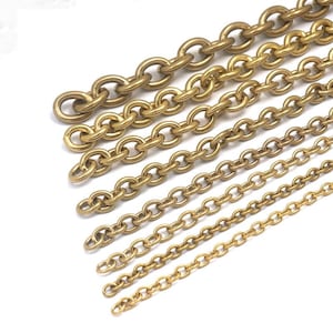 Könnte beinhalten: Eine Sammlung goldfarbener Metallketten in verschiedenen Größen, diagonal angeordnet vor weißem Hintergrund. Die Ketten bestehen aus ineinandergreifenden ovalen Gliedern und weisen unterschiedliche Stärken und Designs auf. Geeignet für Schmuck oder Bastelprojekte.
