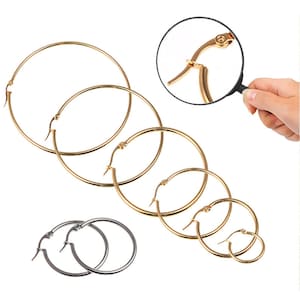 May include: Set of five gold hoop earrings of varying sizes. The earrings have a hinged clasp.