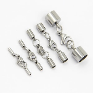 May include: Set of five silver-toned metal end caps for jewellery making. The end caps are different sizes and have a lobster clasp attached.