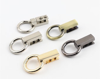 May include: Five metal swivel clasps with a ring and a rectangular bar. The clasps are in different finishes: silver, gold, antique brass, and black.