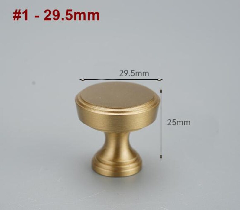 Op de afbeelding: Een gouden kastknop met een ronde bovenkant en een cilindrische basis. De knop is 29,5 mm in diameter en 25 mm hoog. #1 - 29,5 mm