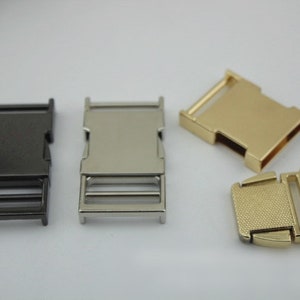 May include: Four metal slider buckles in different finishes: black, silver, gold, and gold with a textured finish.