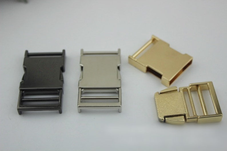 May include: Four metal slider buckles in different finishes: black, silver, gold, and gold with a textured finish.