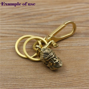 May include: A gold-colored keychain featuring a detailed gorilla head pendant. The keychain includes a split ring and a lobster clasp for easy attachment. The text "Example of use" is in the upper left corner.