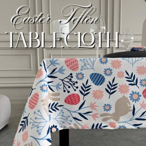Może przedstawiać: Biały obrus z kolorowym wzorem jajek wielkanocnych i kwiatów. Obrus ma powtarzający się wzór niebieskich, różowych i czerwonych jajek, niebieskich kwiatów i zielonych liści. Tekst "Easter Teflon Tablecloth" jest wyświetlany w górnej części obrazu.