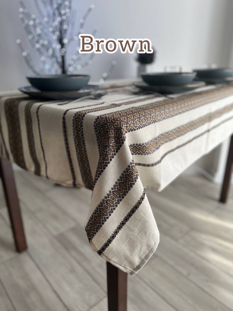 May include: A brown and white striped tablecloth with a geometric pattern. The tablecloth is made of linen and has a rustic look.