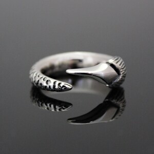 Puede incluir: Un anillo de plata con una banda texturizada y un dise&ntilde;o de garra puntiagudo.