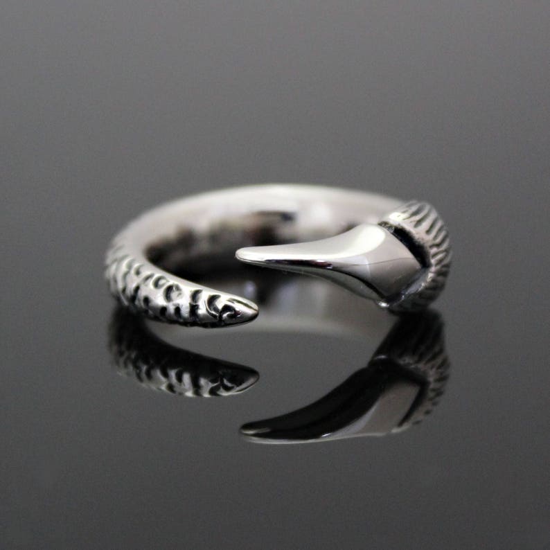 Puede incluir: Un anillo de plata con una banda texturizada y un dise&ntilde;o de garra puntiagudo.