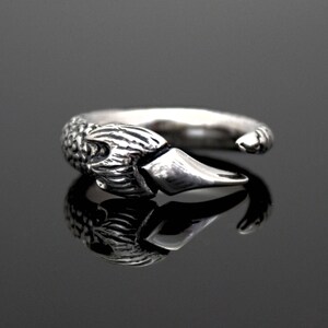Puede incluir: Un anillo de plata con un dise&ntilde;o de garra detallado. La garra es texturizada y tiene una punta afilada.