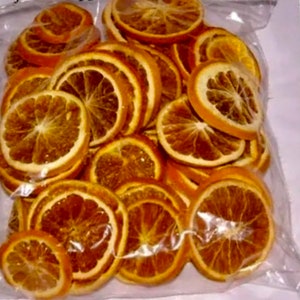 May include: A clear plastic bag filled with dried orange slices. The orange slices are a deep orange color and have a slightly translucent appearance.