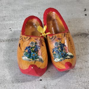 Paar alte kleine Bergclogs aus Holz mit Blumenmotiven
