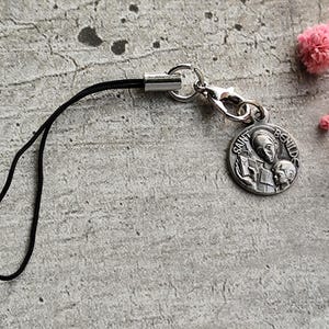 Pulsera para celular con medalla religiosa antigua de Santa Benilde en color plata, ¡lleva tu fe contigo a todas partes!