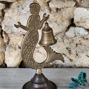 Antique brass bell in the shape of a mermaid