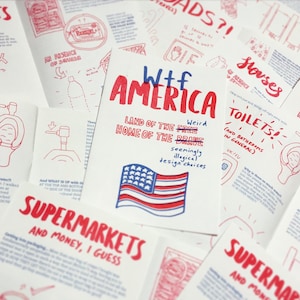 May include: A white card with red and blue text and a drawing of the American flag. The text reads "Wtf America, Land of the Free, Home of the Brave, Weird seemingly illogical design choices".