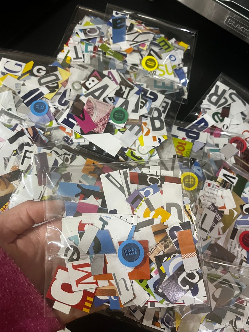 May include: A clear plastic bag filled with colorful paper scraps, including letters, numbers, and other shapes. The bag is labeled "MAYA'S MAKES".