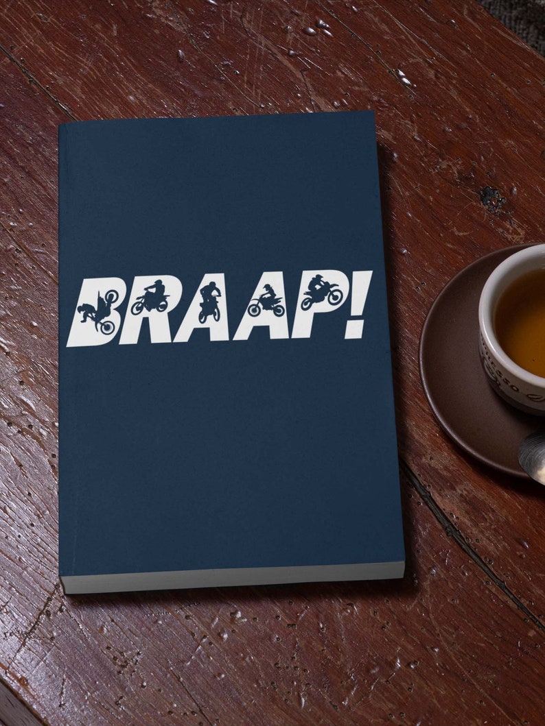 May include: A dark blue notebook with the word "BRAAP!" printed in white. The word is surrounded by silhouettes of motocross riders.