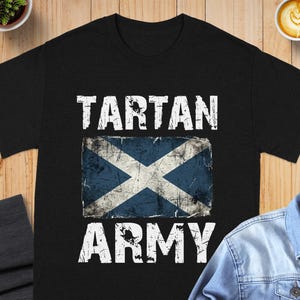 Black t-shirt with distressed Scottish flag and "TARTAN ARMY" text.