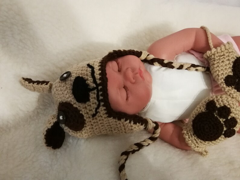 Together in wool cap and mittens baby reindeer and small dog carry by hand crochet