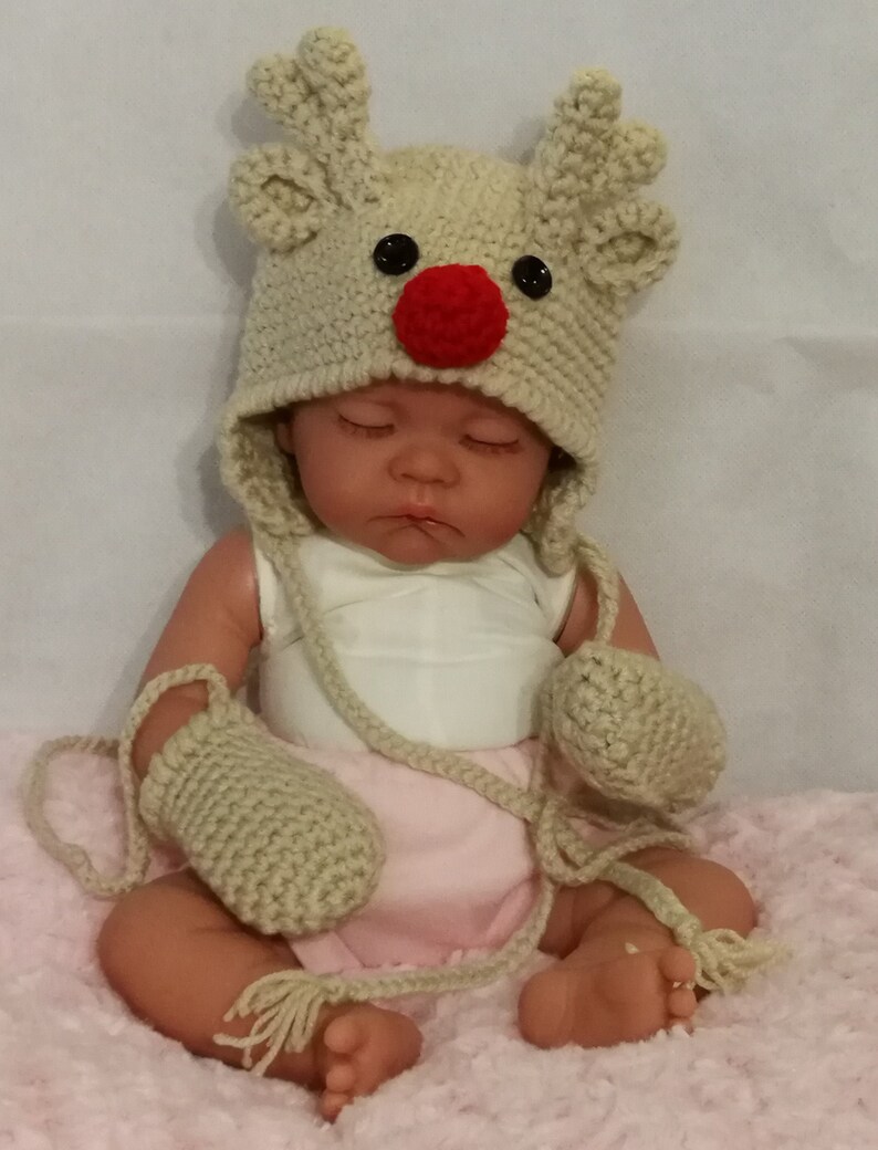 Together in wool cap and mittens baby reindeer and small dog carry by hand crochet