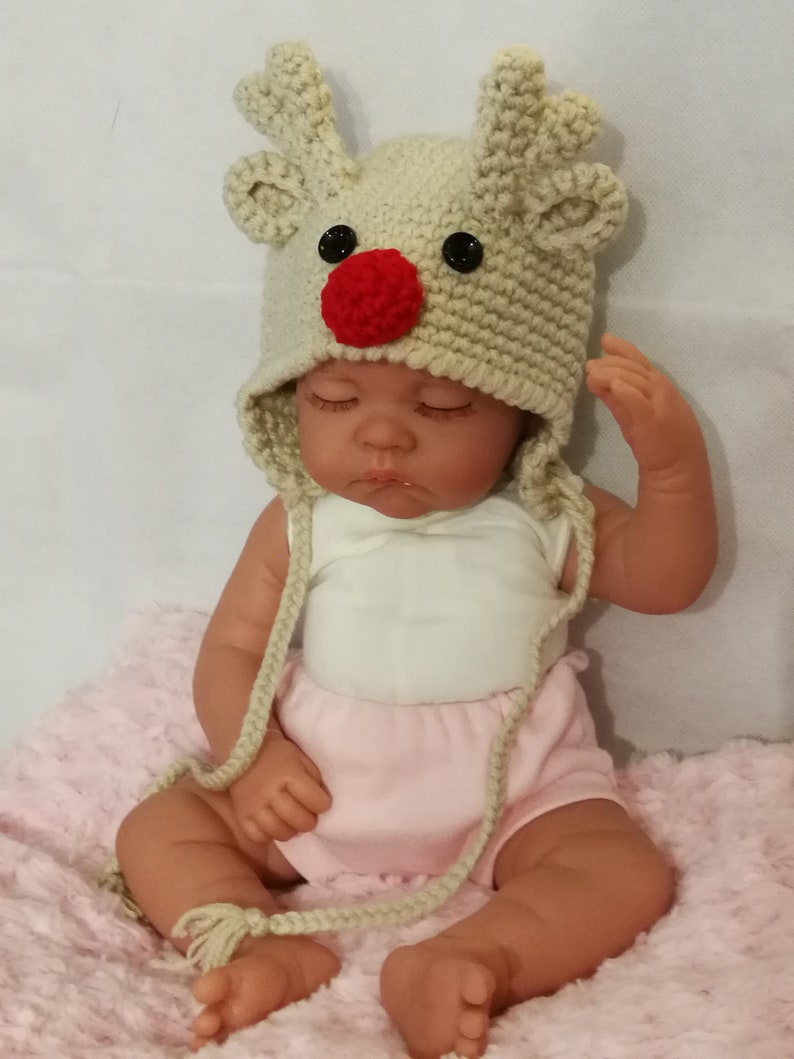 Together in wool cap and mittens baby reindeer and small dog carry by hand crochet