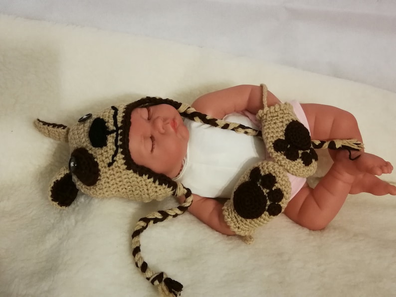 Together in wool cap and mittens baby reindeer and small dog carry by hand crochet