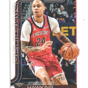 May include: A basketball trading card featuring Jordan Hawkins of the New Orleans Pelicans. Hawkins is wearing a red jersey with the number 24 and the word "CRESCENT" on the front. The card has a white border and the Topps logo.