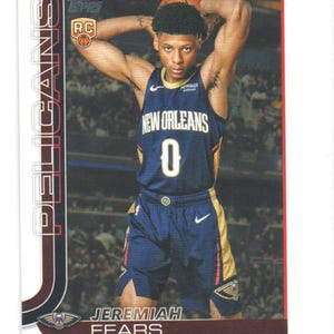 May include: A New Orleans Pelicans basketball trading card featuring Jeremiah Fears. The card has a dark blue and gold color scheme, with the player in his team uniform. The card includes the team logo and player's name.