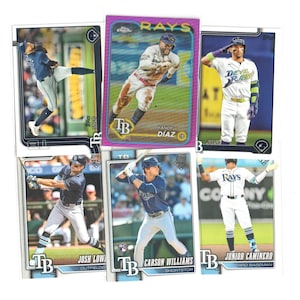 May include: A collection of six baseball trading cards featuring Tampa Bay Rays players in various action poses, including Yandy Díaz, Josh Lowe, Carson Williams, and Junior Caminero, with team logos and player names printed on the card borders.