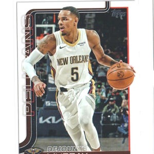 May include: A Topps trading card featuring Dejounte Murray of the New Orleans Pelicans. Murray is wearing a white jersey with the number 5 and the words "New Orleans" across the chest. He is dribbling a basketball. The card has a brown border.