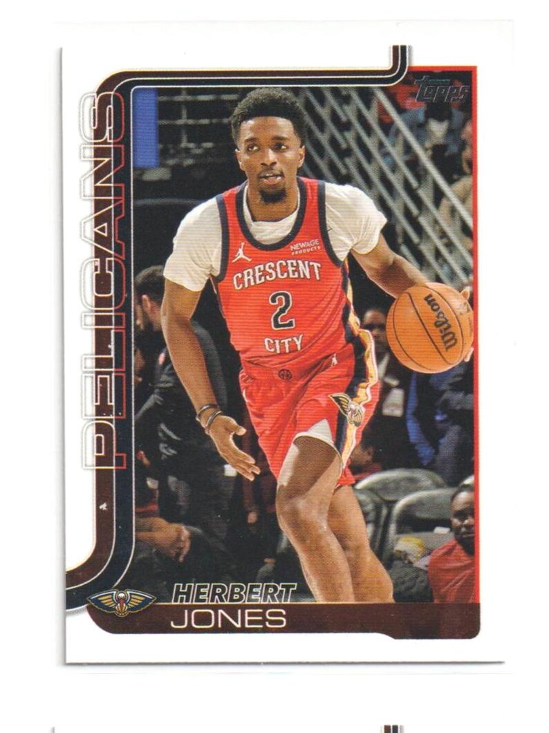 May include: A Topps trading card featuring Herbert Jones of the New Orleans Pelicans. Jones is wearing a red and white basketball jersey with the number 2. He is dribbling an orange Wilson basketball. The card has the Pelicans logo and team name.