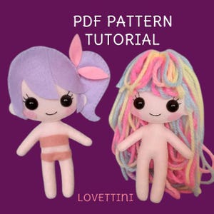 Può includere: Modello PDF e tutorial per realizzare due bambole di feltro. Una bambola ha i capelli viola con un fiocco rosa e l'altra ha i capelli di lana arcobaleno.