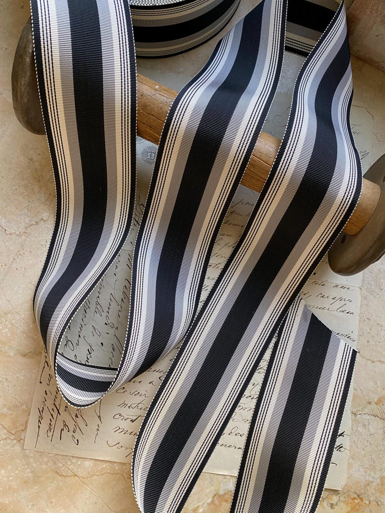 May include: Black and white striped ribbon with a satin finish. The ribbon is approximately 1 inch wide.