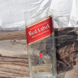 May include: Empty glass bottle with a red label that says "Johnnie Walker Red Label Blended Scotch Whisky Established 1820".