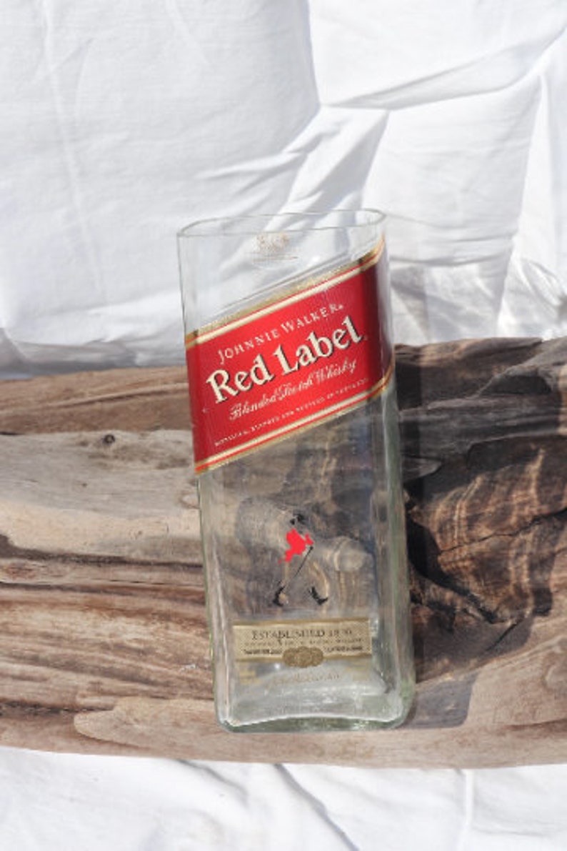 May include: Empty glass bottle with a red label that says "Johnnie Walker Red Label Blended Scotch Whisky Established 1820".