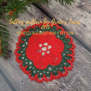 May include: A red and green crocheted doily with a flower design. The doily is on a wooden surface. The text "tatting pattern by Grace's Laces, 2015 GRACESLACESBOUTIQUE.ETSY.COM" is visible in the image.