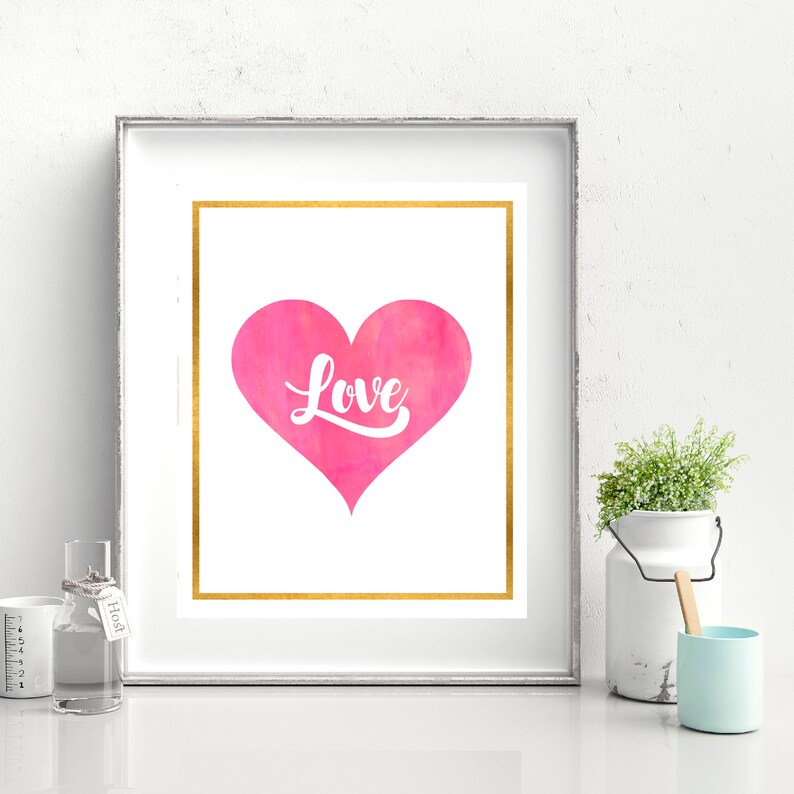 May include: A pink watercolor heart with the word "Love" in white text on a white background with a gold frame.
