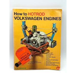 May include: A vintage book titled "How to Hotrod Volkswagen Engines" with an engine diagram on the cover. The cover is yellow with red and black text. An orange exhibitor pass is attached to the book.