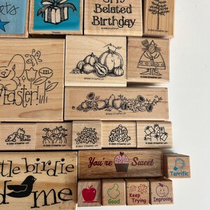 May include: A collection of wooden stamps with various designs and text. Designs include pumpkins, a witch, Easter imagery, and the words "Belated Birthday" and "You're Sweet". The stamps are for crafting and scrapbooking.