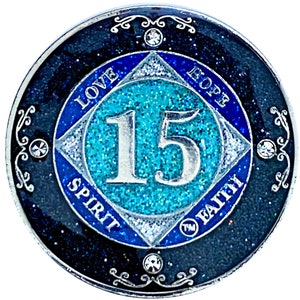 NA 15 jaar glitter- en kristallenmedaillon, verzilverde munt, zwarte regenboog, blauwe glitter en vier heldere kristallen, met epoxy bedekt