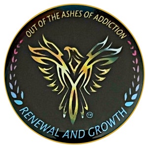 May include: A circular emblem with a black background and gold trim. The emblem features a stylized phoenix with the words "OUT OF THE ASHES OF ADDICTION" and "RENEWAL AND GROWTH" in gold lettering. A colorful border surrounds the emblem.