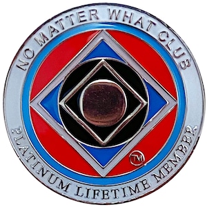 Puede incluir: Un pin redondo plateado con fondo blanco y el texto "NO MATTER WHAT CLUB PLATINUM LIFETIME MEMBER" alrededor del borde. El centro del pin presenta un cuadrado negro con un círculo plateado en su interior, rodeado de un cuadrado rojo, azul y blanco.