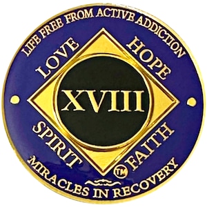 Puede incluir: Una medalla redonda de recuperación azul y dorada. El centro presenta el número romano XVIII en oro sobre un fondo negro. El anillo exterior tiene el texto "LIFE FREE FROM ACTIVE ADDICTION" y "MIRACLES IN RECOVERY". También están presentes las palabras "LOVE", "HOPE", "SPIRIT" y "FAITH".