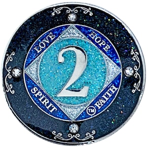 May include: A silver coin with a blue and white glitter background. The number "2" is in the center of the coin. The words "Love", "Hope", "Spirit", and "Faith" are around the edge of the coin.