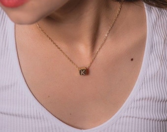 Collar con dije de letra y diamantes en forma de cubo