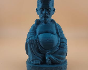 May include: A teal blue 3D printed figurine of a Buddha with a Frankenstein-like face.