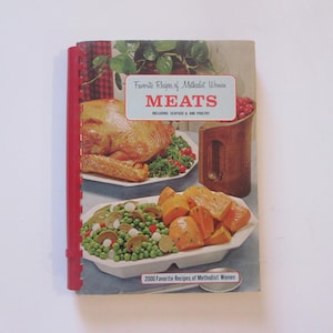 May include: A vintage cookbook titled "Favorite Recipes of Methodist Women MEATS INCLUDING SEAFOOD & POULTRY" with a red spine and a photo of a roasted turkey, sweet potatoes, and green beans on the cover.