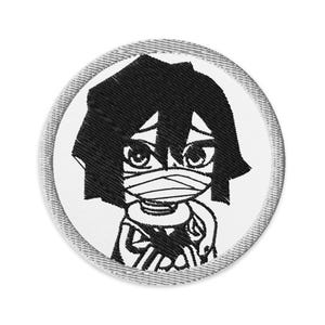 May include: Circular embroidered patch with a black and white anime-style character design. The character has black hair, large eyes, and a bandage over their mouth. The patch has a white background and a grey stitched border.
