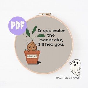 Op de afbeelding: Een kruissteekpatroon met een cartoon-mandragora-plant in een pot met de tekst "Als je de mandragora wakker maakt, betover ik je."