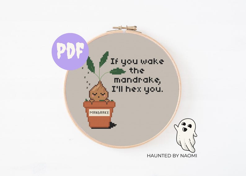 Op de afbeelding: Een kruissteekpatroon met een cartoon-mandragora-plant in een pot met de tekst "Als je de mandragora wakker maakt, betover ik je."